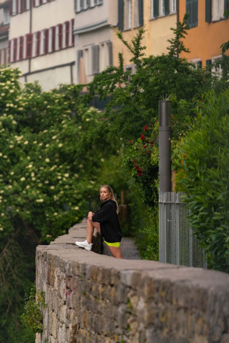 Sportlerin beim Dehnen an der Mauer